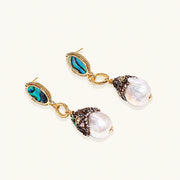 Gold drop earrings with iridescent abalone studs, rope links, jeweled caps and white baroque pearls on cream background