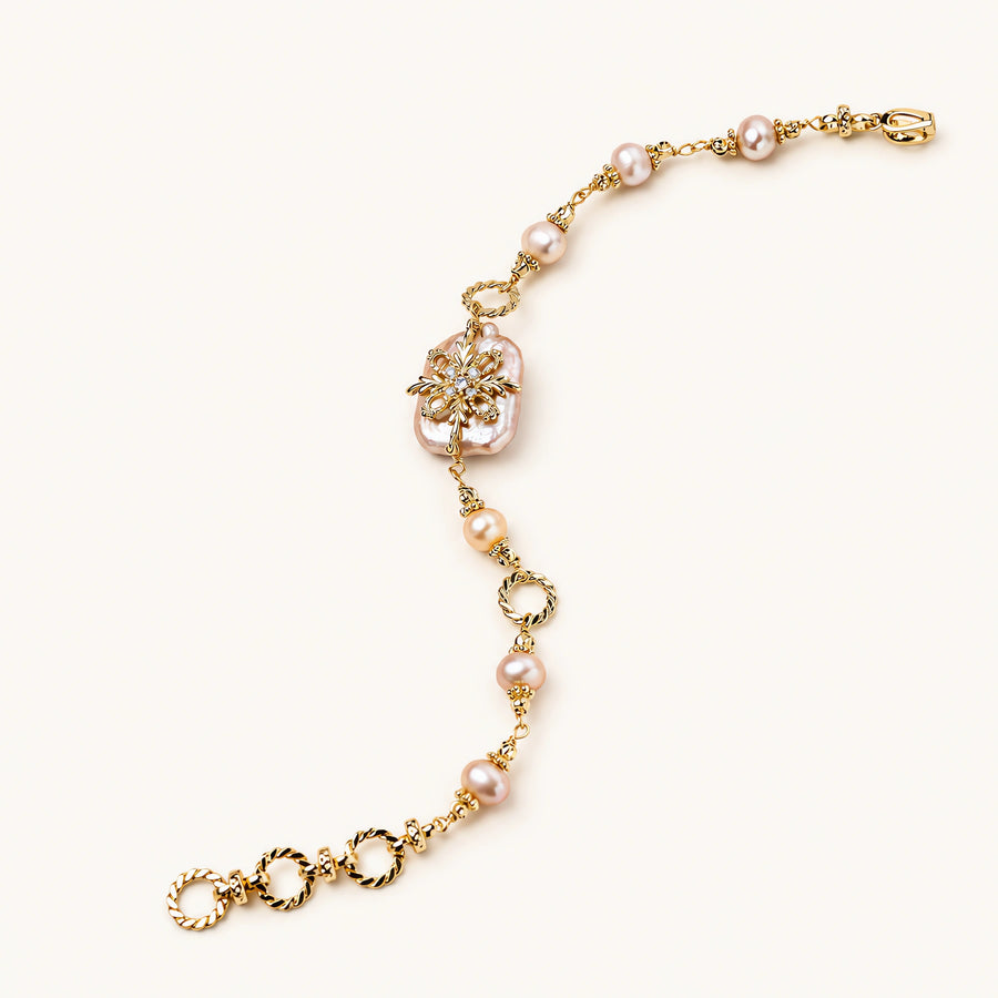 Gold-plated bracelet with pink baroque pearl centerpiece, floral connector, and freshwater pearls