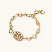 Gold-plated bracelet with pink baroque pearl centerpiece, floral connector, and freshwater pearls