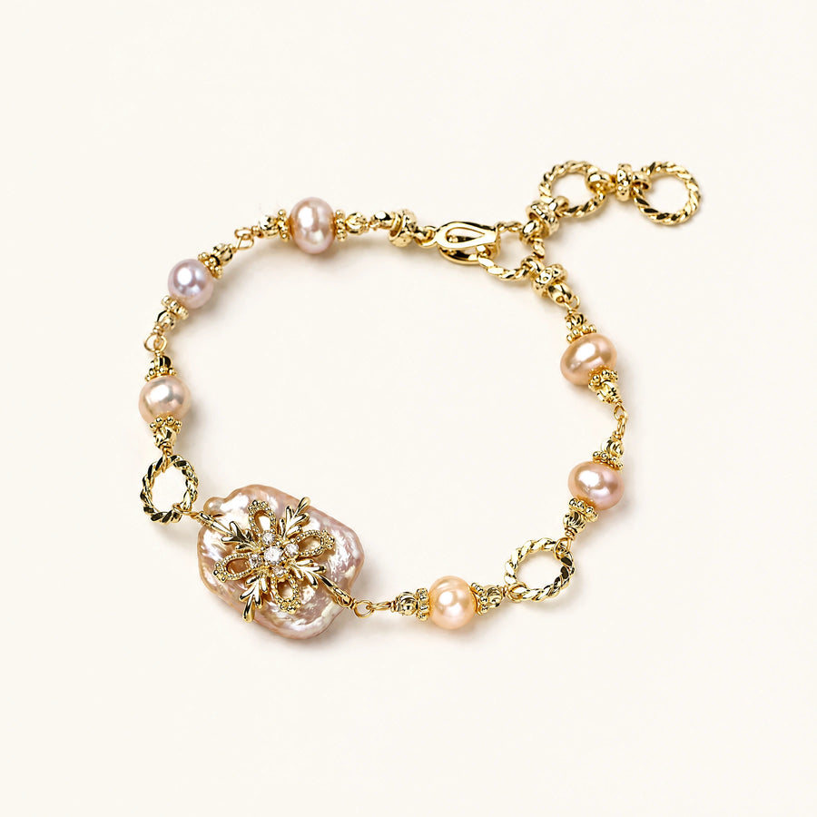 Gold-plated bracelet with pink baroque pearl centerpiece, floral connector, and freshwater pearls