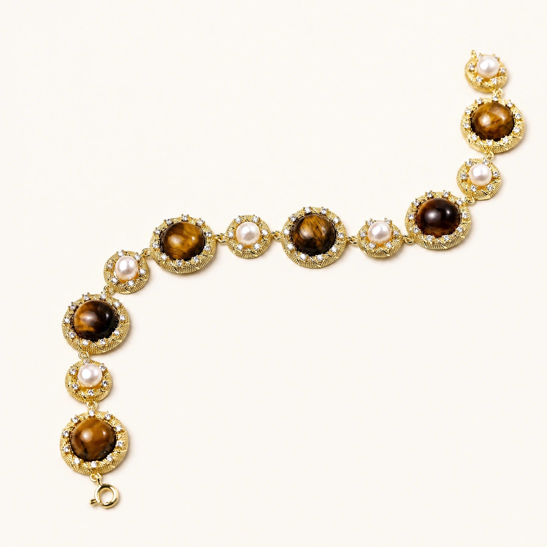 Gold-plated link bracelet with alternating brown tiger's eye stones and white freshwater pearls in ornate bezels.