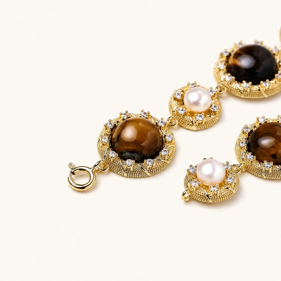 Gold-plated link bracelet with alternating brown tiger's eye stones and white freshwater pearls in ornate bezels.