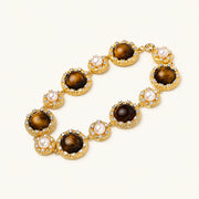 Gold-plated link bracelet with alternating brown tiger's eye stones and white freshwater pearls in ornate bezels.
