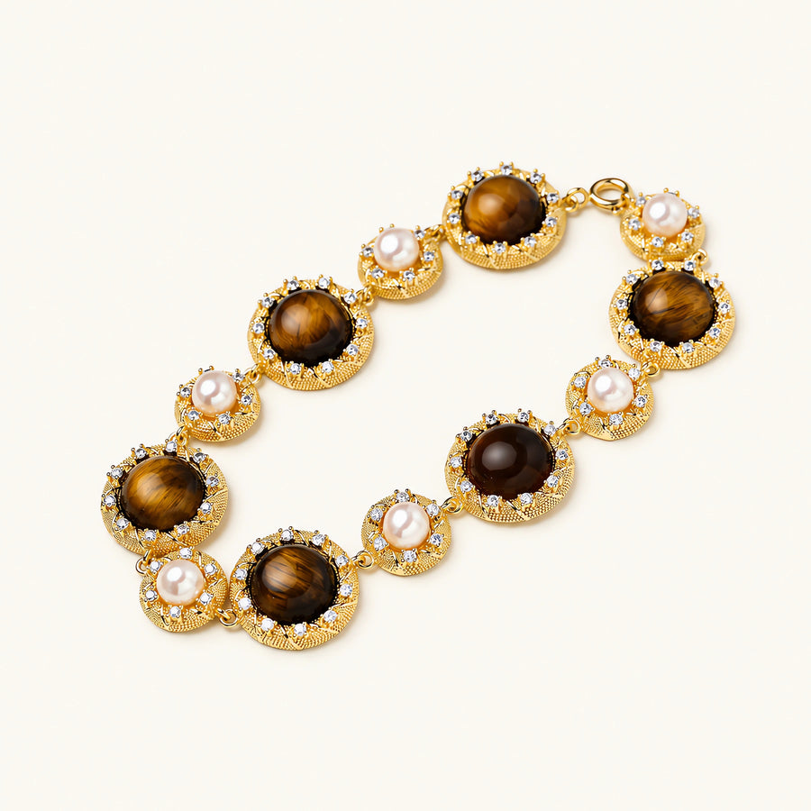 Gold-plated link bracelet with alternating brown tiger's eye stones and white freshwater pearls in ornate bezels.