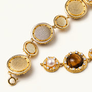 Gold-plated link bracelet with alternating brown tiger's eye stones and white freshwater pearls in ornate bezels.