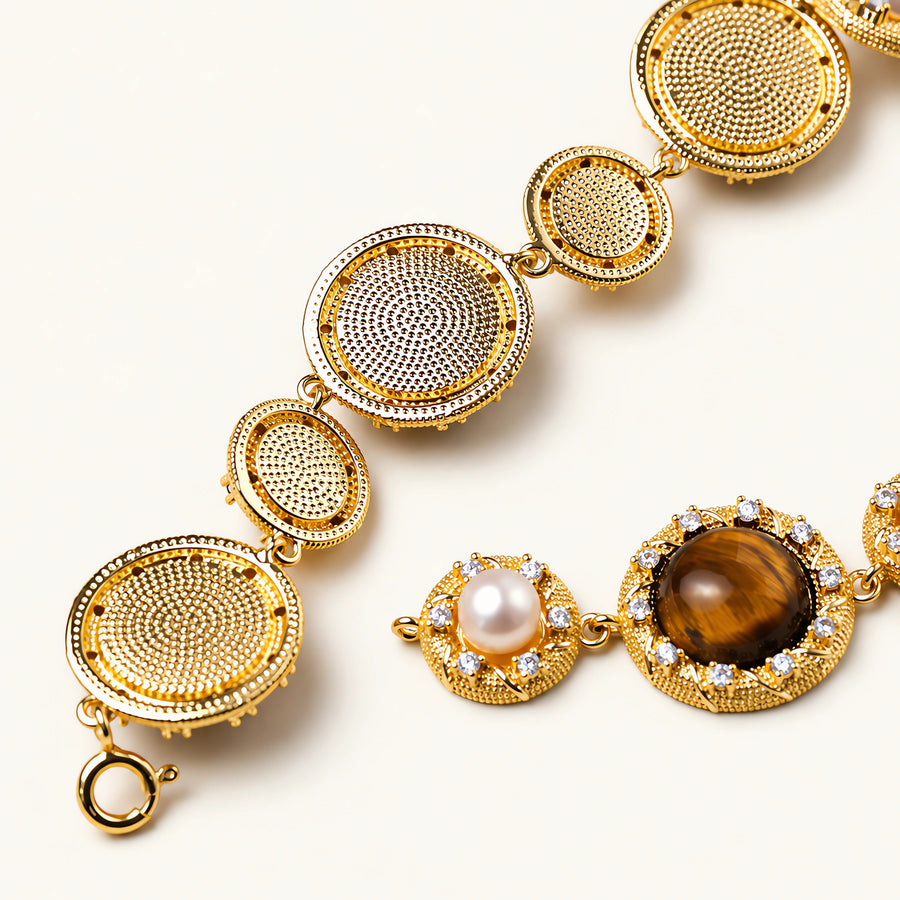 Gold-plated link bracelet with alternating brown tiger's eye stones and white freshwater pearls in ornate bezels.
