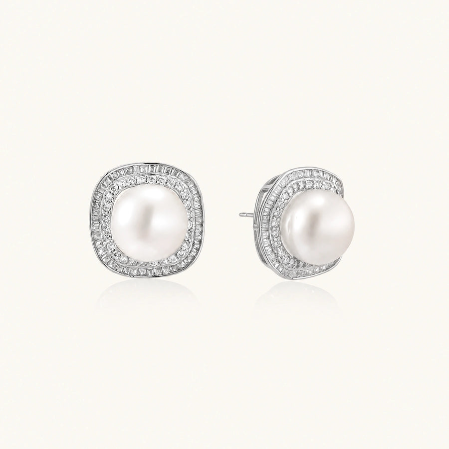 Rhodium-plated sterling silver stud earrings with round freshwater pearls surrounded by geometric crystal halos on cream background.