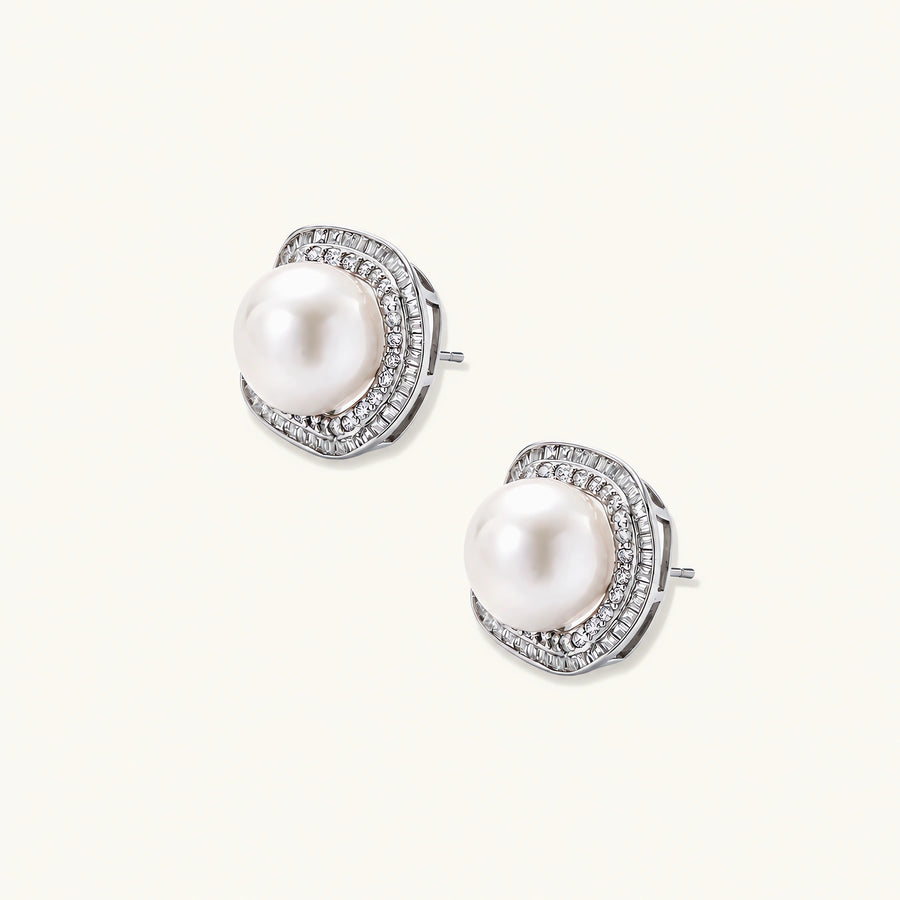 Rhodium-plated sterling silver stud earrings with round freshwater pearls surrounded by geometric crystal halos on cream background.