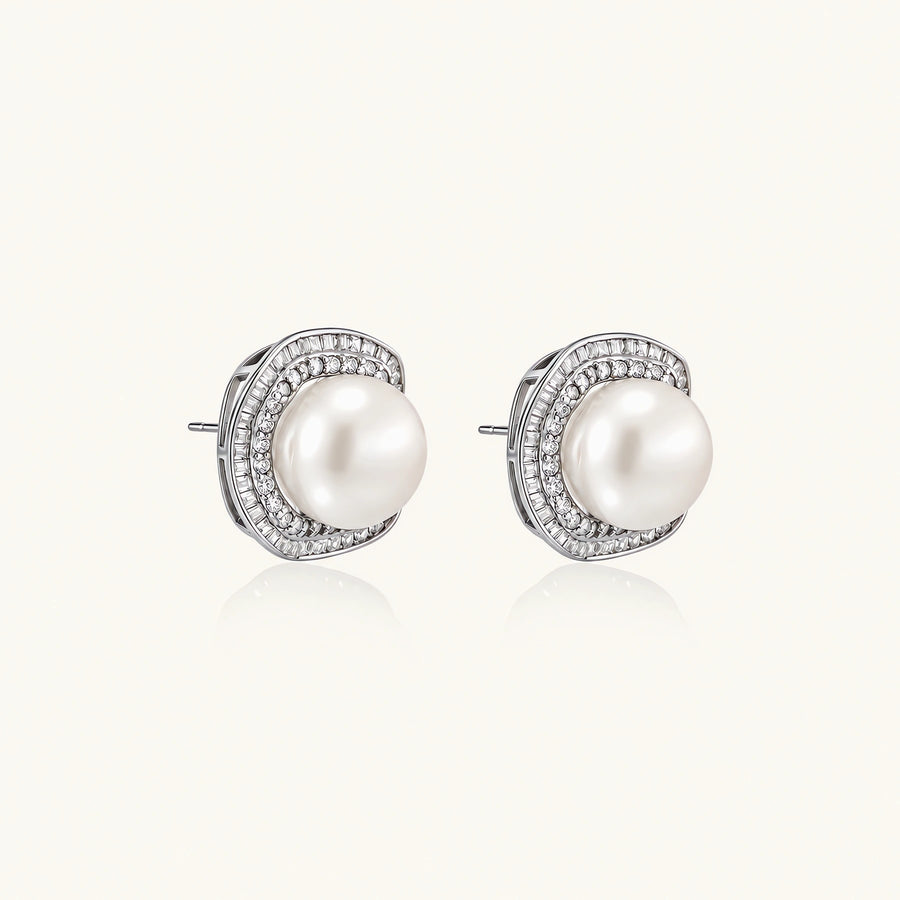 Rhodium-plated sterling silver stud earrings with round freshwater pearls surrounded by geometric crystal halos on cream background.