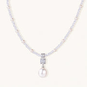 Dainty necklace with lavender crystal beads, freshwater pearls, geometric pendant, and large pearl drop on white background.