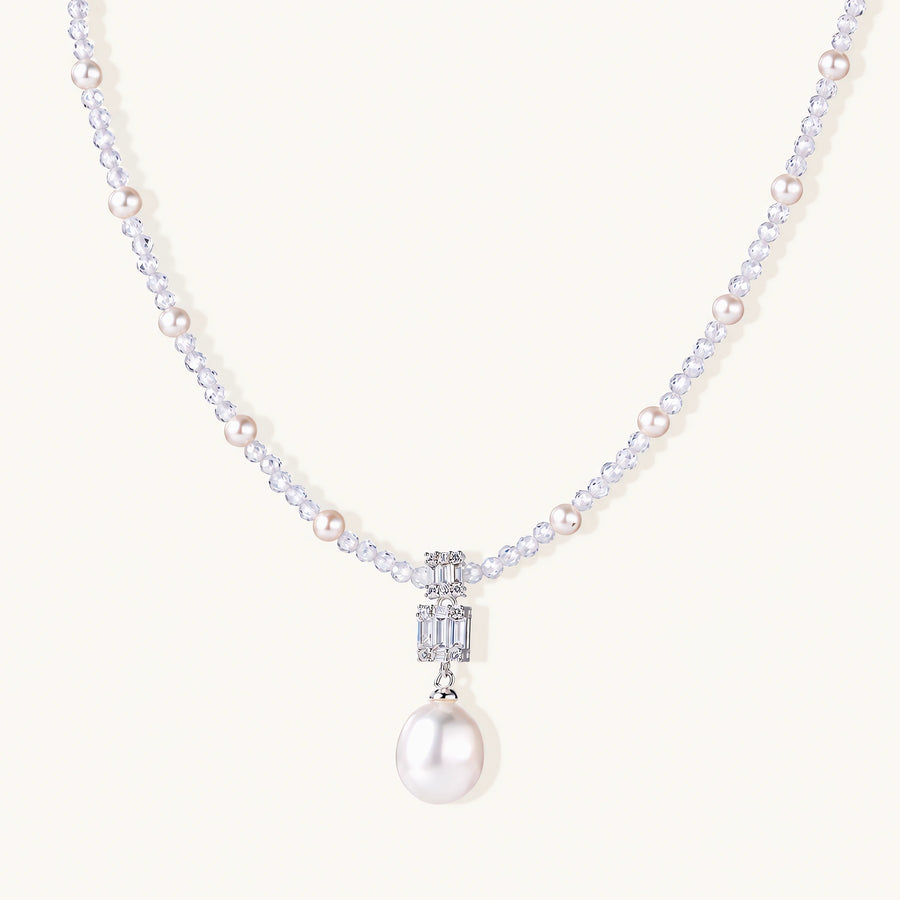 Dainty necklace with lavender crystal beads, freshwater pearls, geometric pendant, and large pearl drop on white background.