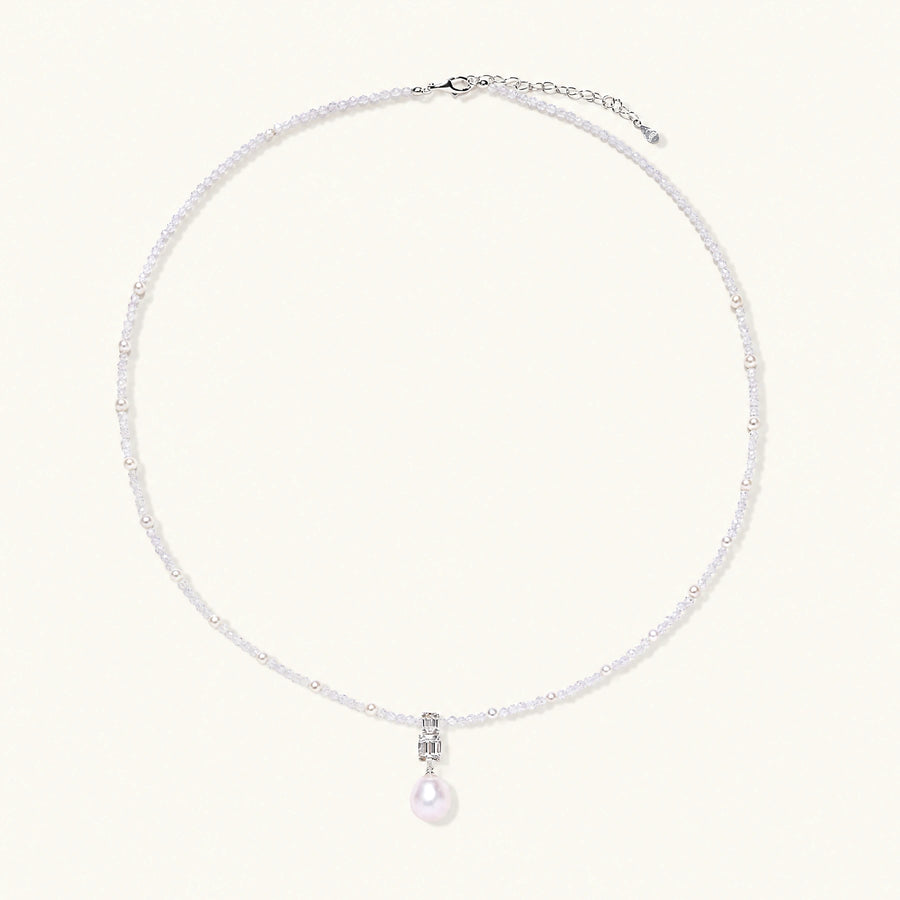 Dainty necklace with lavender crystal beads, freshwater pearls, geometric pendant, and large pearl drop on white background.