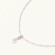 Dainty necklace with lavender crystal beads, freshwater pearls, geometric pendant, and large pearl drop on white background.