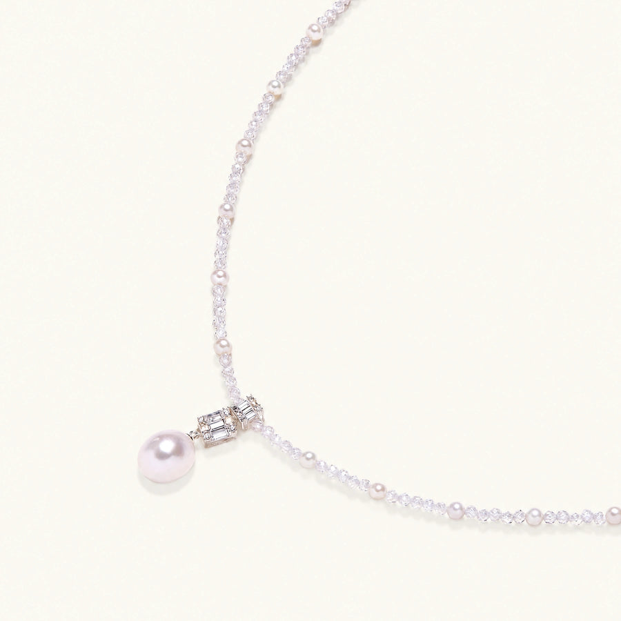 Dainty necklace with lavender crystal beads, freshwater pearls, geometric pendant, and large pearl drop on white background.