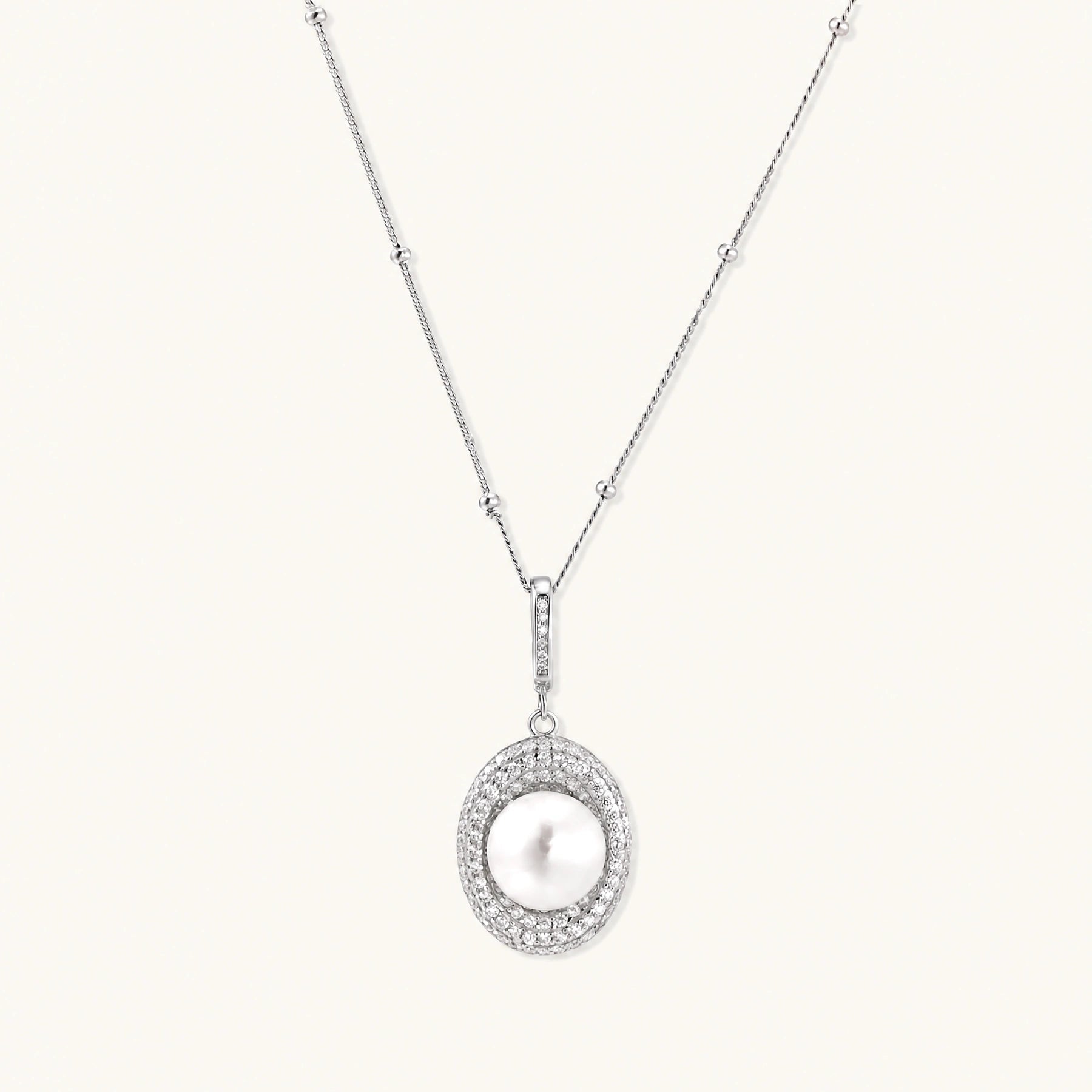 Oval sterling silver pendant with crystal halo surrounding a white freshwater pearl on delicate chain