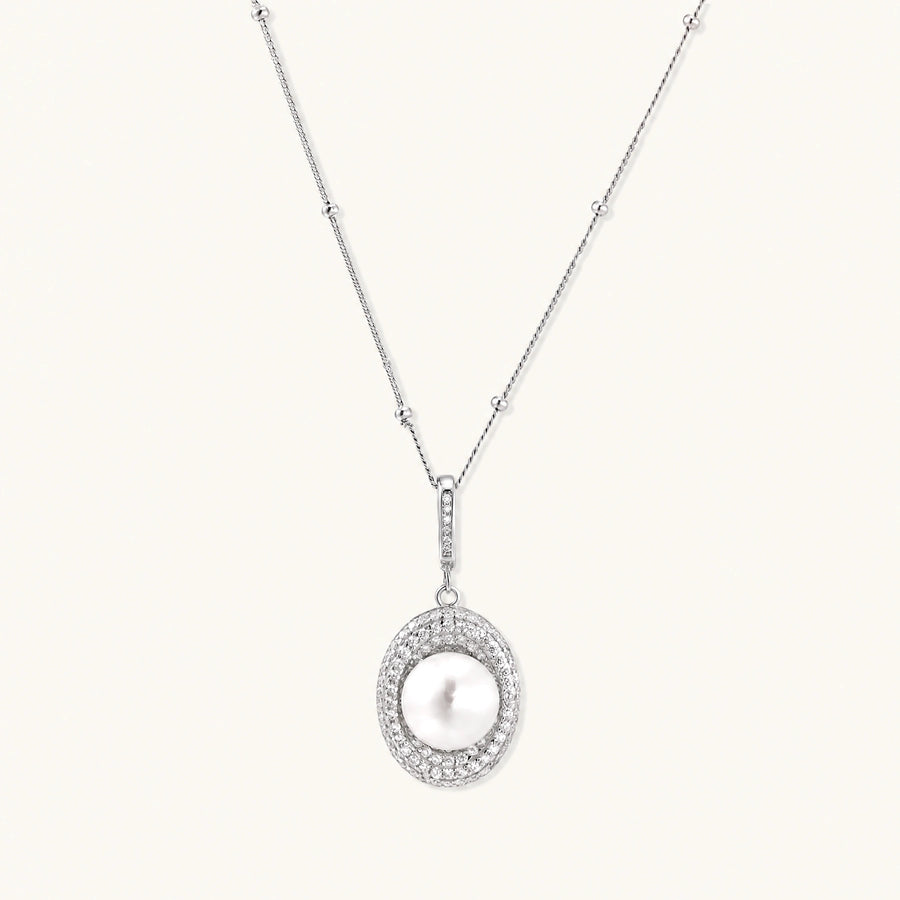 Oval sterling silver pendant with crystal halo surrounding a white freshwater pearl on delicate chain