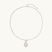 Oval sterling silver pendant with crystal halo surrounding a white freshwater pearl on delicate chain