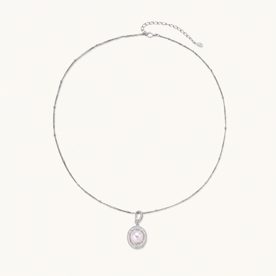 Oval sterling silver pendant with crystal halo surrounding a white freshwater pearl on delicate chain