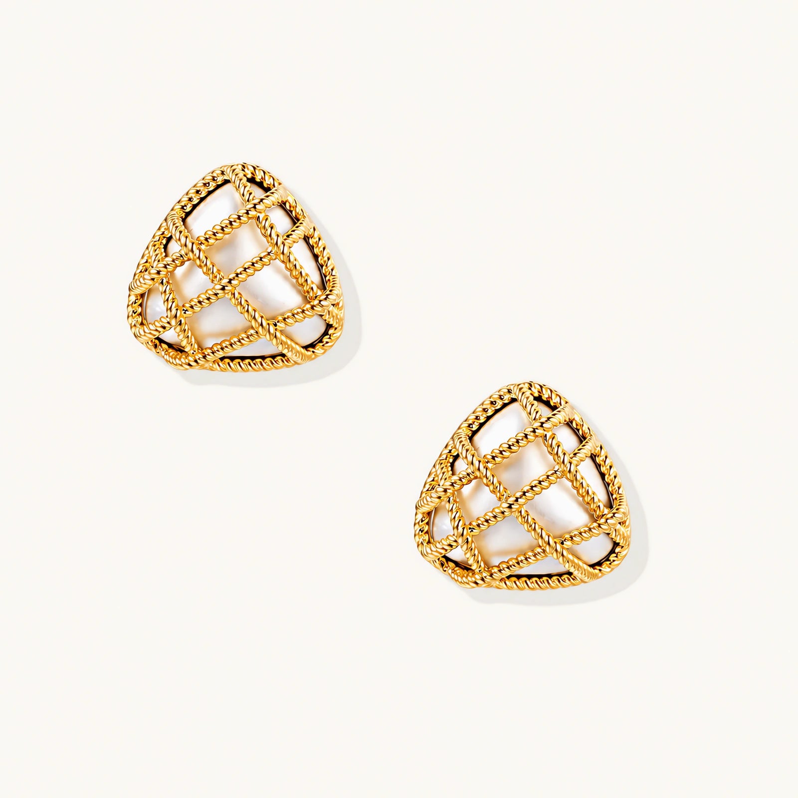 Pair of triangular gold-plated earrings with rope-textured lattice pattern on cream background, dimensional stud design