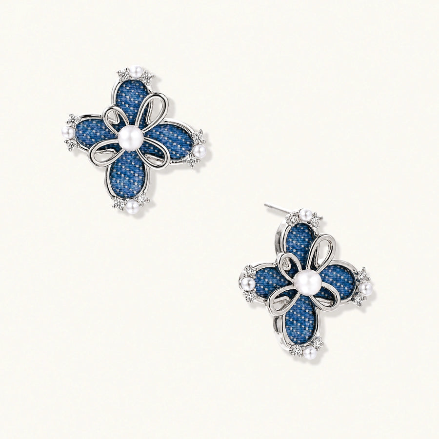 Pair of silver-tone four-petal flower stud earrings with blue denim fabric petals, a center white bead and zirconia accents.