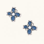 Pair of silver-tone four-petal flower stud earrings with blue denim fabric petals, a center white bead and zirconia accents.