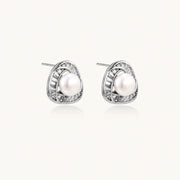 Triangular white gold plated stud earrings with central freshwater pearl and baguette-cut stones on white background