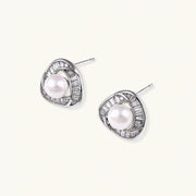 Triangular white gold plated stud earrings with central freshwater pearl and baguette-cut stones on white background