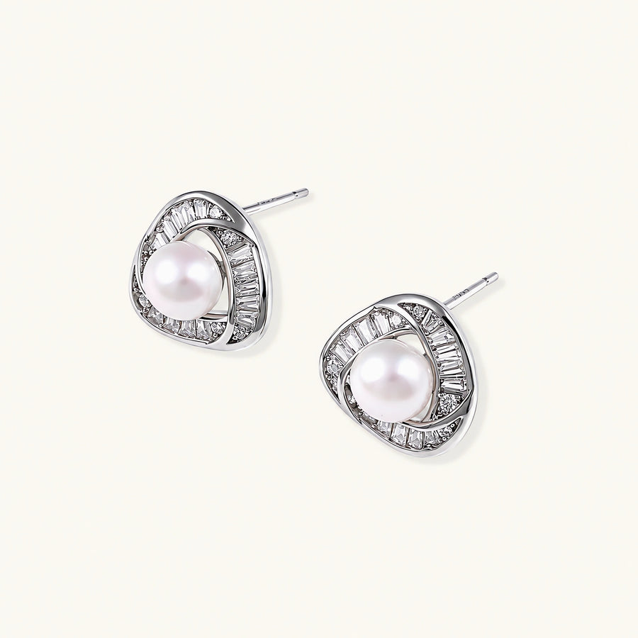 Triangular white gold plated stud earrings with central freshwater pearl and baguette-cut stones on white background