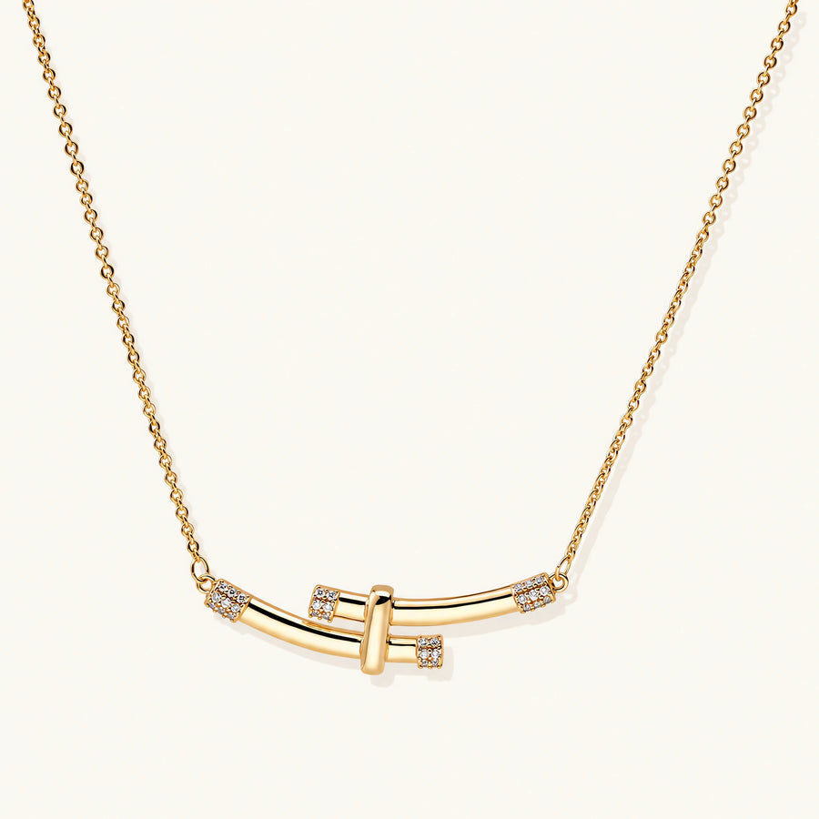 Gold-plated curved bar necklace with diamond accents on delicate chain against cream background