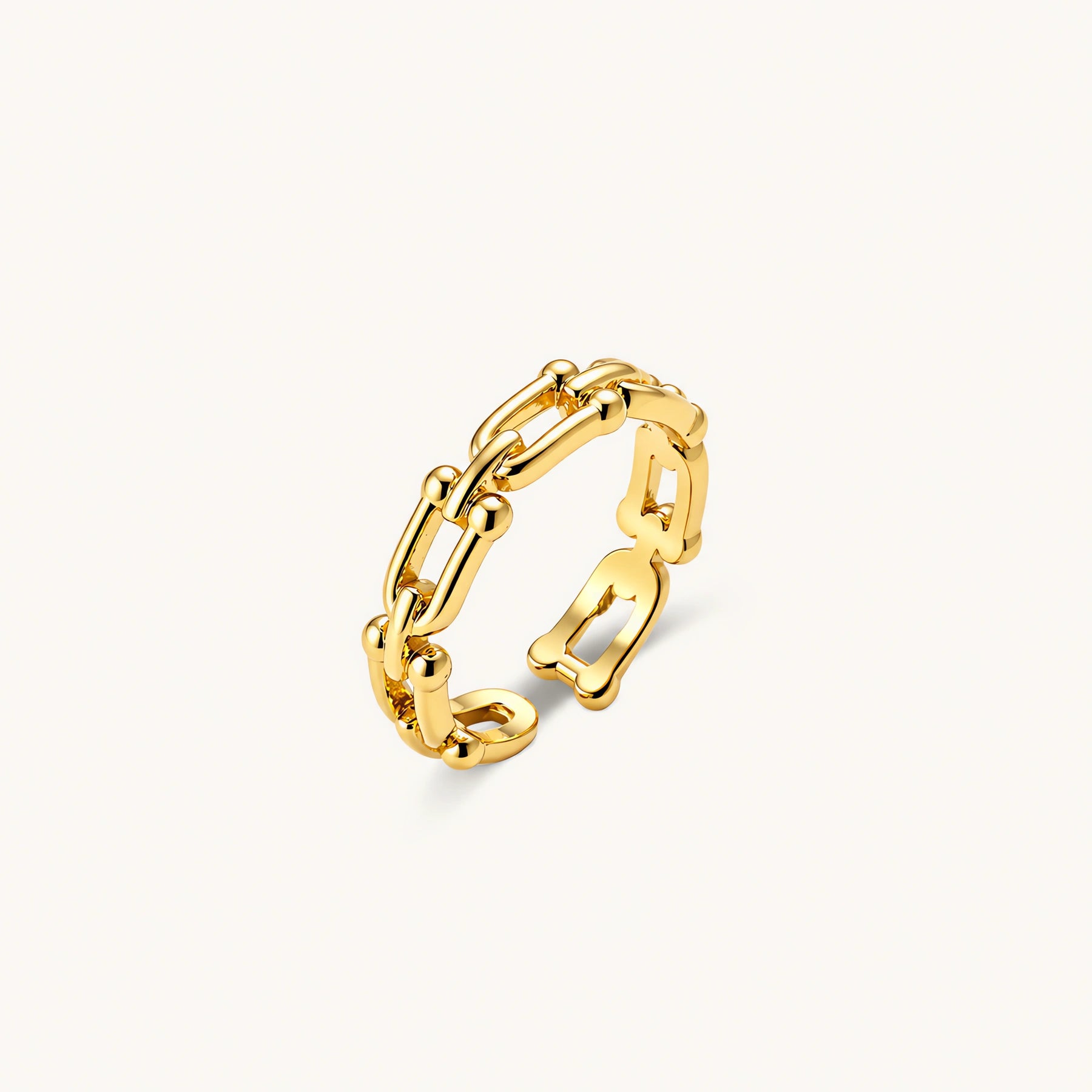 Two adjustable gold rings: chain-link band and halo-style ring with cubic zirconia stones on cream background