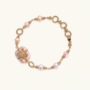 Gold-plated bracelet with pink baroque pearl centerpiece, floral connector, and freshwater pearls