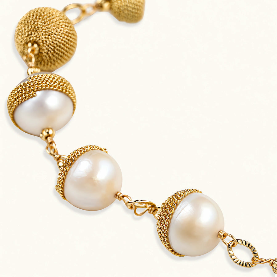 Adjustable bracelet with baroque pearls wrapped in delicate gold mesh netting connected by textured chain links