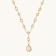 Long gold-plated necklace with alternating freshwater pearls and crystal bezels, featuring a large baroque pearl pendant