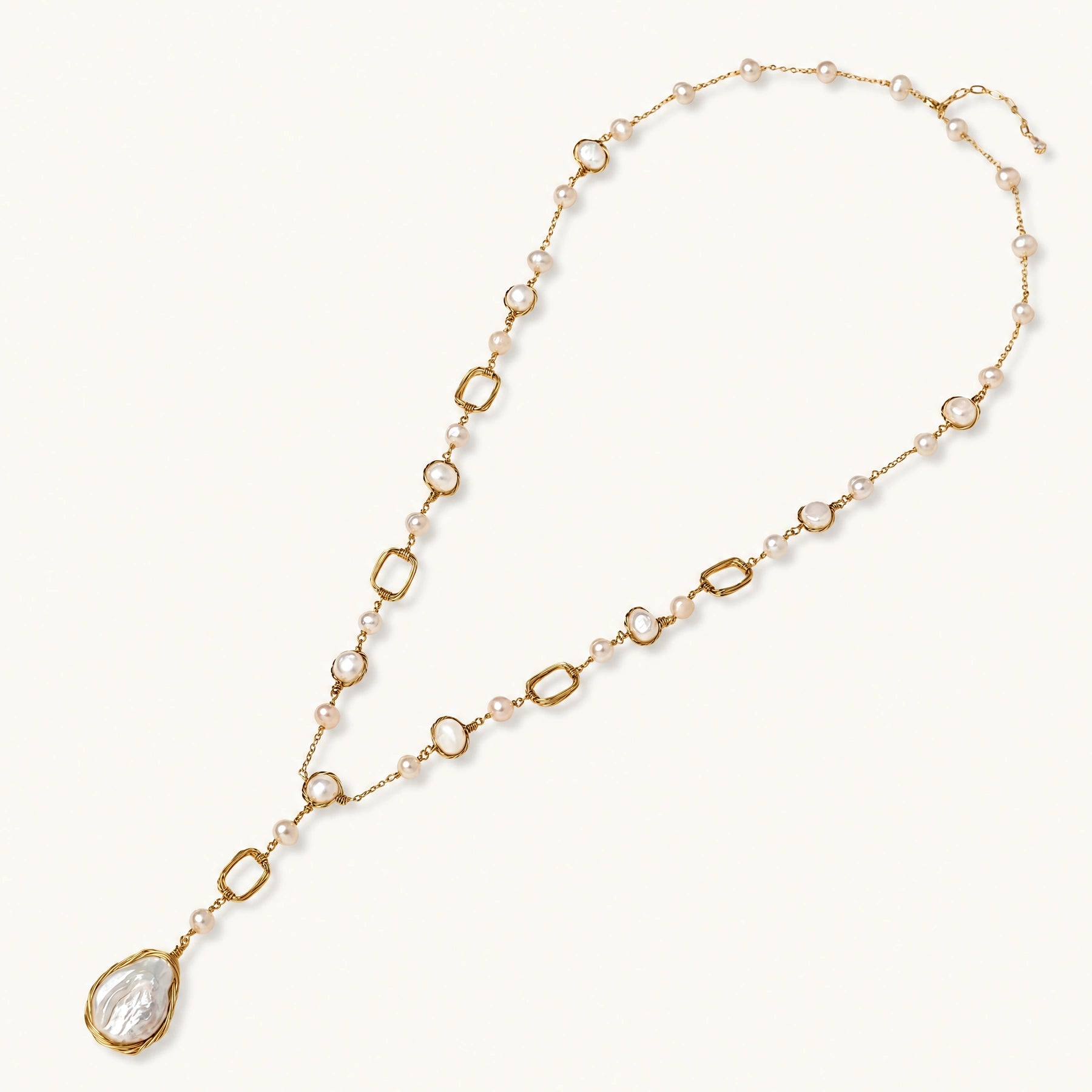 Long gold-plated necklace with alternating freshwater pearls and crystal bezels, featuring a large baroque pearl pendant