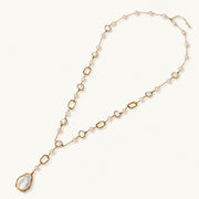 Long gold-plated necklace with alternating freshwater pearls and crystal bezels, featuring a large baroque pearl pendant