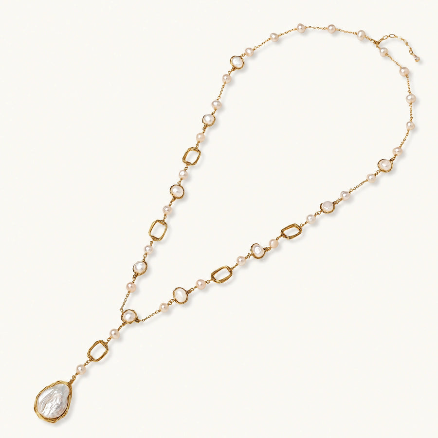 Long gold-plated necklace with alternating freshwater pearls and crystal bezels, featuring a large baroque pearl pendant