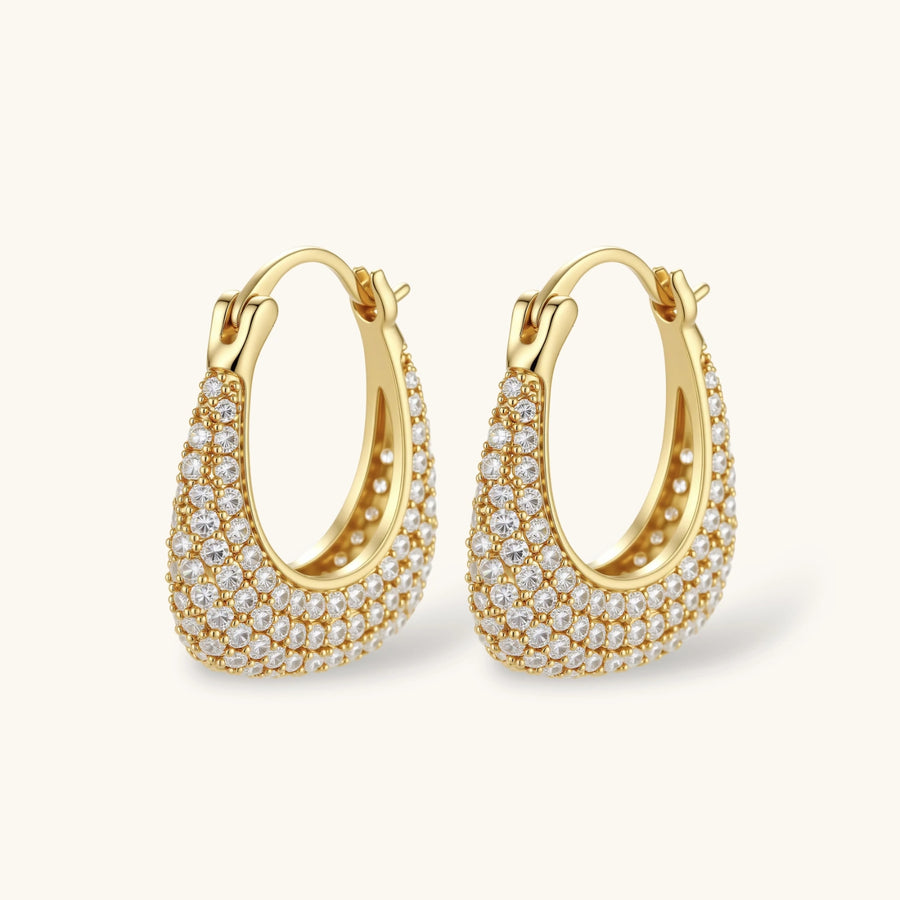 Gold-plated hoop earrings fully covered in sparkling zircon crystals with hinged closure on neutral background