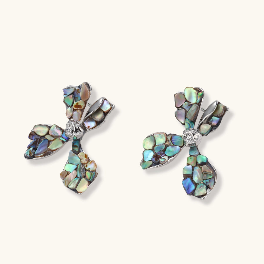 Pair of oversized four-petal flower stud earrings with iridescent teal and blush shell mosaic on silver-tone petals.